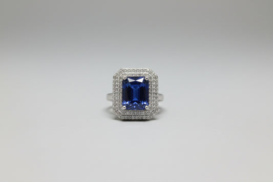 Silver ring with a blue gemstone on a gray surface
