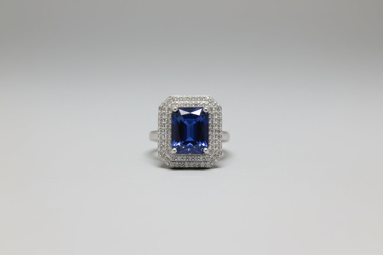 Silver ring with a blue gemstone on a gray surface