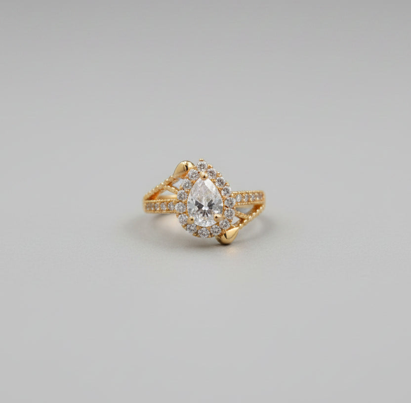 Gold ring with a diamond on a reflective surface