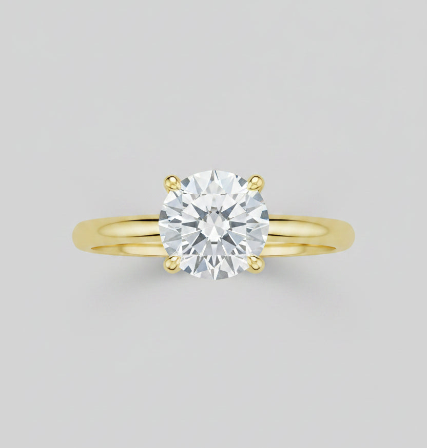 Gold ring with a diamond on a reflective surface
