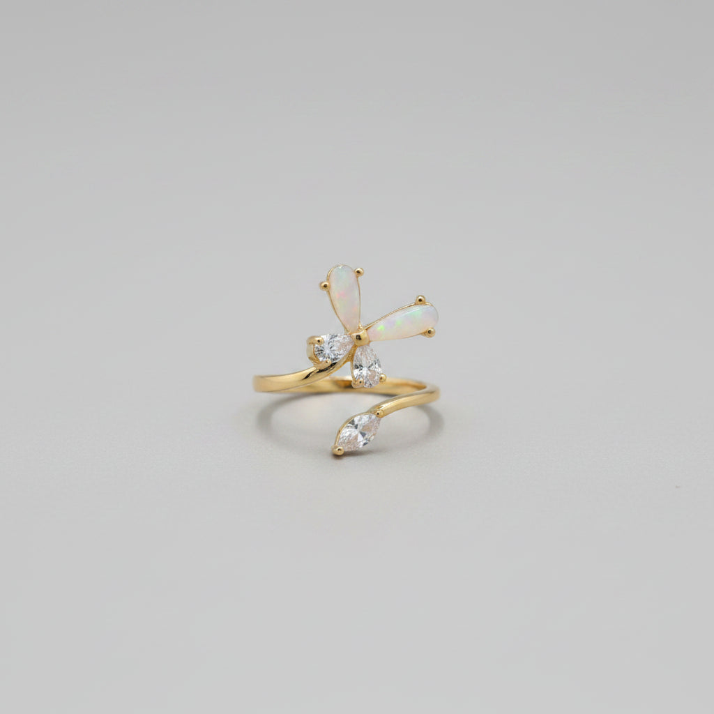 Gold ring with clear stones on a reflective surface