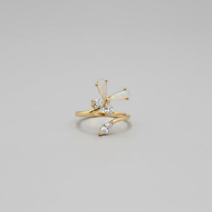 Gold ring with clear stones on a reflective surface