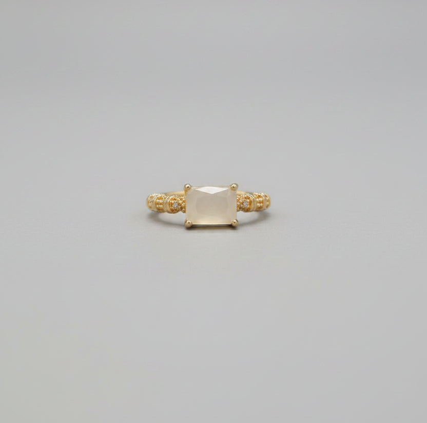 Gold ring on a reflective surface with a blurred background