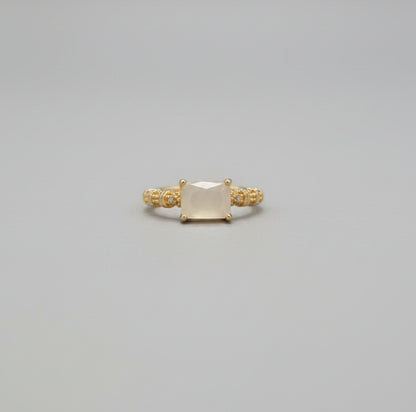 Gold ring on a reflective surface with a blurred background