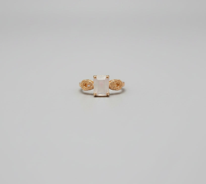 Gold ring on a desk with office chairs and a blurred background
