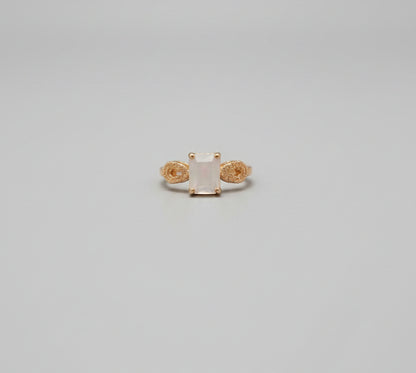 Gold ring on a desk with office chairs and a blurred background