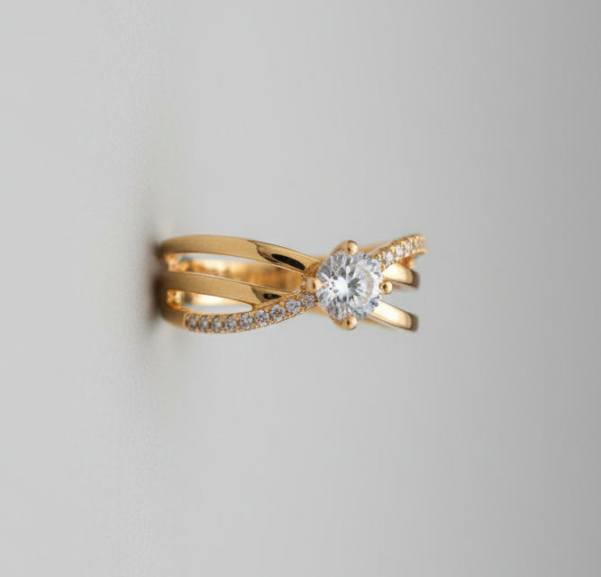 Gold bow-shaped ring with a diamond on a reflective surface