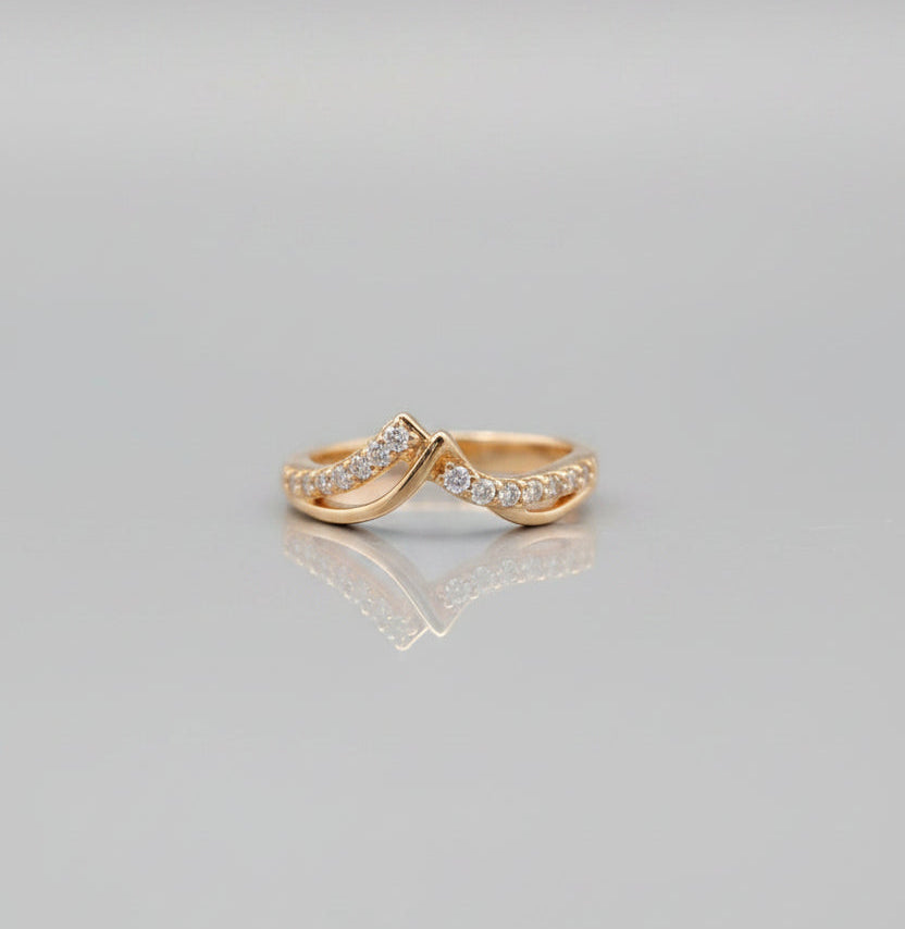Two gold rings with diamond accents on a gray background