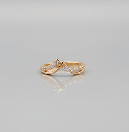 Two gold rings with diamond accents on a gray background