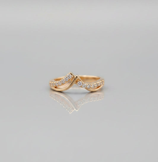 Two gold rings with diamond accents on a gray background