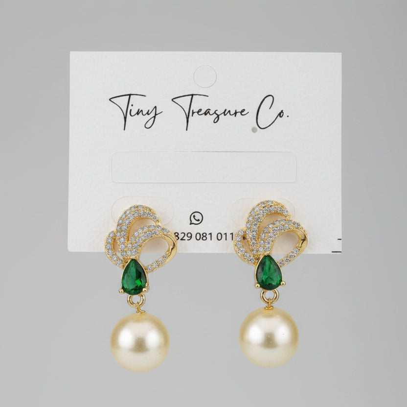 Gold earrings with green gemstones and pearl-like beads on a 'Tiny Treasure Co.' card.
