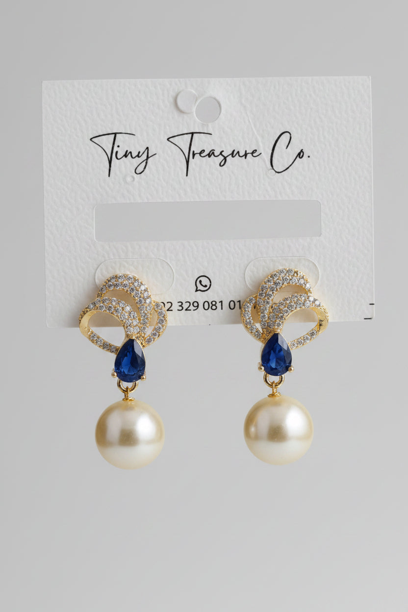 Gold and pearl earrings on a 'Tiny Treasure Co.' card