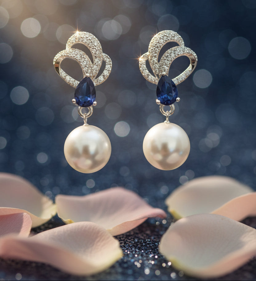 Pair of earrings with pearls and blue stones on a Tiny Treasure Co card.