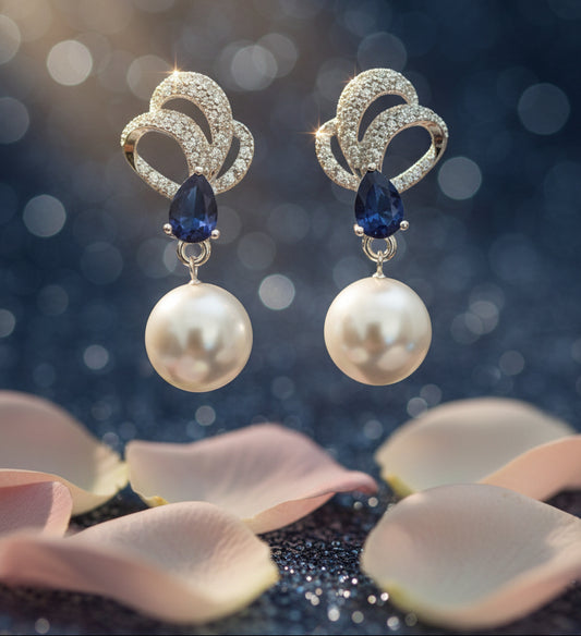 Pair of earrings with pearls and blue stones on a Tiny Treasure Co card.